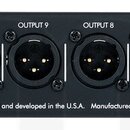 Černý rackový panel s 16 XLR konektory typu female, označenými OUTPUT 1 až OUTPUT 16. Na panelu jsou nápisy Applied Research & Technology, Designed a…
