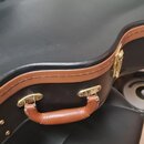 Černý tvrdý kufýr s hnědými koženěnými okraji a úchytem. Na horní části je vyražený nápis Epiphone. Kufýr má kovové zlaté zapínání a úchyt vykazuje m…
