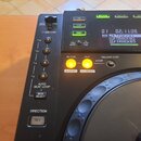 Detailní pohled na černý DJ prohrávač. Na displeji je vidět čas 02:11.08 a seznam skladek TRACK01, TRACK02 a TRACK03. Na panelu jsou nápisy DC5V 500m…