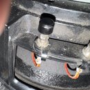 Detailní pohled na vnitřní zapojení elektroniky, pravděpodobně uvnitř reproduktoru. Jsou vidět dvě skleněné pojistky v držácích, z nichž jedna má čer…