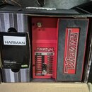 Červený efekt pedál s nápisem Whammy v kartonové krabici. Na horním ovládacím panelu jsou přepínače s označenmi jako HARMONY, CLASSIC a WHAMMY, dále…