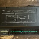 Černý elektronický modul s nápisy YAMAHA, FM EXPANDER a TX7 TONE GENERATOR. Horní kryt obsahuje schéma s texty DX SERIES, DATA ENTRY SLIDER, PROGRAM…