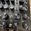 Detailní pohled na ovládací panel černého elektronického zařízení s nápisem DSM HUMBOLDT ELECTRONICS. Panel obsahuje několik černých otočných potenci…