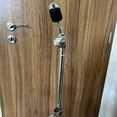 Stříbrný kovový mikrofonní stojan s černou plastovou držákem na mikrofon v horní části. Stojan má teleskopický mechanismus s dvěma viditelnými utahov…