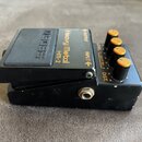 Černý kytarový efekt pedál s nápisy Heavy Metal HM-2 a BOSS. Na pravé straně jsou tři oranžové ovládací knoflíky s popisky LEVEL, COLOR MIX a DIST. Z…