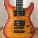 Elektrická kytara s červeno-žlutým plamenovitým povrchem a bílým lemováním. Nástroj má dva humbuckery s nápisem Seymour Duncan a černý most. Na hmatn…