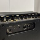 Detailní pohled na ovládací panel a zadní konektory kytarového komba v černé barvě. Na horní části jsou ovládací knoflíky a nápisy Spark 2, TUNER, CL…