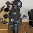 Černý hlavník basové kytary s logem YAMAHA v kruhu a nápisem BROADBASS. Nástroj má pět ladicích kolíčů s kovovými knoflíky. Povrch je v dobrém stavu,…