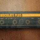 Fotografie znázorňuje černou obalovou krabici s nápisem CHOCOLATE PLUS Wireless Midi Controller. Na krabici je schéma ovládacího panelu s označením k…