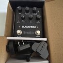 Černý efekt pedál s nápisy BLACKHOLE a Eventide v kartonové krabici. Zařízení má pět otočných ovladačů s popisky Mix, Gravity Delay, Feedback Q, Size…
