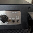 Detailní pohled na ovládací panel černého elektronického zařízení s nápisem PF-800. Na stříbrném kovovém panelu je černý ovratový knoflík s popiskem…