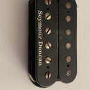 Černý humbucker snímač s dvěma řadami pólů. Na levém krytu je bílý nápis Seymour Duncan. Povrch vykazuje drobné škrábance a opotřebení, zejména u šro…