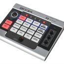 Stříbro-černý vokální procesor s nápisem ZOOM a označením V3 Vocal Processor. Zařízení obsahuje řadu bílých a červených tlačítek s popisky jako HARMO…