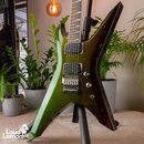 Elektrická kytara s ostrými hranami v zelené metalické barvě, která přechází do tmavě hnědé. Nástroj má dva humbuckery, Floyd Rose mechanismus a stří…