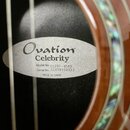 Detail vnitřku akustické kytary s viditelnou štítkem. Na bílém oválném štítku je nápis Ovation Celebrity, Model No. CS28P-KOAB, Serial No. CCV1910037…
