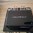 Černý elektronický přístroj s kovovým šasi a čtyřmi stříbrnými ochrannými kletemi pro elektrony. Na horním krytu je bílý nápis INTIMIDATION zobrazený…