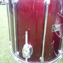 Detail červeného bubnu s chromovaným kováním. Na korpusu je černý štítek s bílým nápisem MAPEX, pod ním MARS SERIES a v dolní části MADE IN TAIWAN. P…