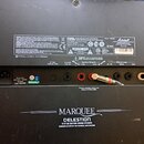 Zadní panel černého kytarového komba. V horní části jsou bílé varovné texty v několika jazycích, logo CE a značka Marshall s označením MODEL: MH204C.…