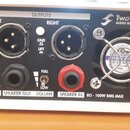 Zadní strana bílého elektronického zařízení značky Two notes AUDIO ENGINEERING. Jsou zde vidět konektory POWER (12VDC 200mA), dva XLR výstupy označen…
