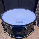 Černý buben s bílým blátcem. Na blátci je modrý nápis EVANS a uprostřed je vidět křížový zářez. Na korpusu je umístěno logo MAPEX s nápisemの下 Percuss…