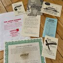 Fotografie zobrazuje sadu papírových dokumentů a manuálů k hudebnímu nástroji značky Gretsch. Je zde vidět záruční list s nápisem GRETSCH GUITAR GUAR…