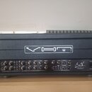 Černý kytarový zesilovač v ochranném kufru. Na horním panelu je bílý nápis VHT a v pravé dolní části logo SigX s doplňkem DYNAMIC SENSING TECHNOLOGY.…