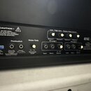 Detail zadní strany černého kytarového zesilovače. Jsou zde vidět ovládací prvky a konektory s nápisy CAUTION !, Footswitch, Noise Gate, Low / High G…