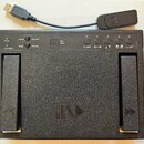 Černý plastový USB pedál s dvěma stoupacími spínači. Na horní části jsou nápisy Power, Joystick, Keyboard, vPedal, Alternate, LED on/off a Pg up/Dn s…