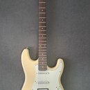 Elektrická kytara s krémovým trupem a hnědým hmatníkem. Na hlavě je nápis Blond. Nástroj má tři snímače typu single-coil, bílý pickguard a chromovaný…