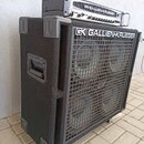 Černý basový kombozesilovač tvořený dvěma moduly. Spodní část je velký reproduktorový box potažený černým textilem s kovovou mřížkou a nápisem GK GAL…