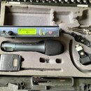 V šedém polstrování kufru je umístěn bezdrátový mikrofonní systém značky SENNHEISER. Set obsahuje přijímač s nápisy TRUE DIVERSITY RECEIVER ew 500 a…