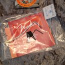 Sada příslušenství položená na šedém plyšovém povrchu. V horní části je balení strun s nápisy D'Addario, XL, NICKEL WOUND, REGULAR LIGHT GAUGE, EXL11…