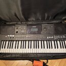 Černý digitální klavír značky YAMAHA, model PSR-E463, umístěný v černém polstrovaném pouzdře. Nástroj má bílé a černé klávesy a horní panel s displej…