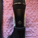 Černý dynamický mikrofon s mřížkou, umístěný v držáku. Na horním okraji těla je nápis DYNAMIC cardioid a TELEFUNKEN. Uprostřed těla se nachází čtverc…