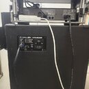 Zadní strana černého basového komba s nápisem GALLIEN KRUEGER. Na zadním panelu je štítek s textem "MODEL NO: 212-II" a "MAX WATTS", ovládací prvek s…