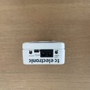 Bílý kytarový pedál s nápisem tc electronic. Na zadní straně jsou dva jackové vstupy označené jako 9V IN a TUNING, USB port s ikonou a nápisem DISPLA…