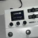 Bílý kytarový procesor s nápisem LINE 6 na předním panelu. Displej zobrazuje logo LINE 6, název modelu HX STOMP a text Firmware 3.80.0. Zařízení má t…