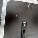 Fotografie zachycuje černý transportní kufr s hliníkovým profilem a kovovými rohy. Povrch kufrů vykazuje známky opotřebení ve formě několika světlých…