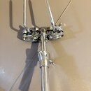 Chromovaný kovový stojan na bicí činely. Horní část obsahuje držák s dvěma vyčnívajícími hroty a mechanismus pro upevnění. Povrch je lesklý, s vidite…