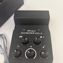 Černý kompaktní mixér s nápisy Roland a GO:MIXER PRO-X. Zařízení má pět ovládacích knoflíků a kontrolky s popisky POWER a PEAK. Vedle knoflíků jsou b…