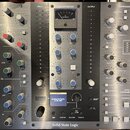 Stříbrný rackový procesor s nápisy Solid State Logic, BUS COMPRESSOR a COMPRESSOR. Zařízení obsahuje řadu otočných knoflíků, bílých tlačítek a analog…