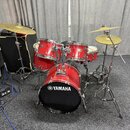 Červená bicí souprava značky YAMAHA s černým předním bendem basového bubnu, na kterém je bílé logo a nápis YAMAHA. Sestava obsahuje basový buben, dva…