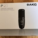 Fotografie znázorňuje krabici od kondenzátorového mikrofonu. Na bílém povrchu je nápis P120, CONDENSER MICROPHONE a text GENERAL PURPOSE RECORDING MI…