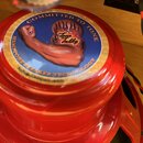 Červený reproduktor s kulatou nálepkou v horní části. Na modrém pozadí nálepky je nápis COMMITTED TO TONE, obrázek svalovité paže a logo Tone Tubby v…