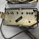 Fotografie zachycuje vnitřek kovového šasi efektu nebo elektronického modulu s viditelným opotřebením a oxidací povrchu. Uvnitř jsou rozmístěny šroub…