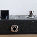 Černý efekt pedál s texturou kovového povrchu. Na horní straně je nápis DITTO LOOPER a logo tc electronic, černý plastový oválkový knoflík a kovový s…