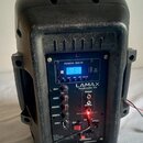 Černý plastový reproduktor s ovládacím panelem. Na panelu jsou nápisy POWER: 300 W, LAMAX, PartyBoomBox 300 a označení ovladačů VOL, BASS, TREBLE, MI…