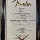 Fotografie zobrazuje Certifikát pravosti (Certificate of Authenticity) značky Fender. Dokument obsahuje datum 03/15/2023, model LTD CUSTOM JMASTER RE…