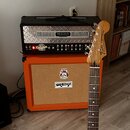 Kytarový zesilovač s nápisem MESA ENGINEERING a modelem DUAL Rectifier NOV WAVE umístěný na oranžovém kytarovém kombu značky ORANGE. Před přístroji s…