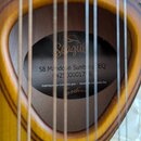 Detail znamení v otvoru rezonanční skříně mandoliny s žlutým povrchem. Na štítku je nápis Seagull, model S8 Mandolin Sunburst EQ a sériové číslo 0425…